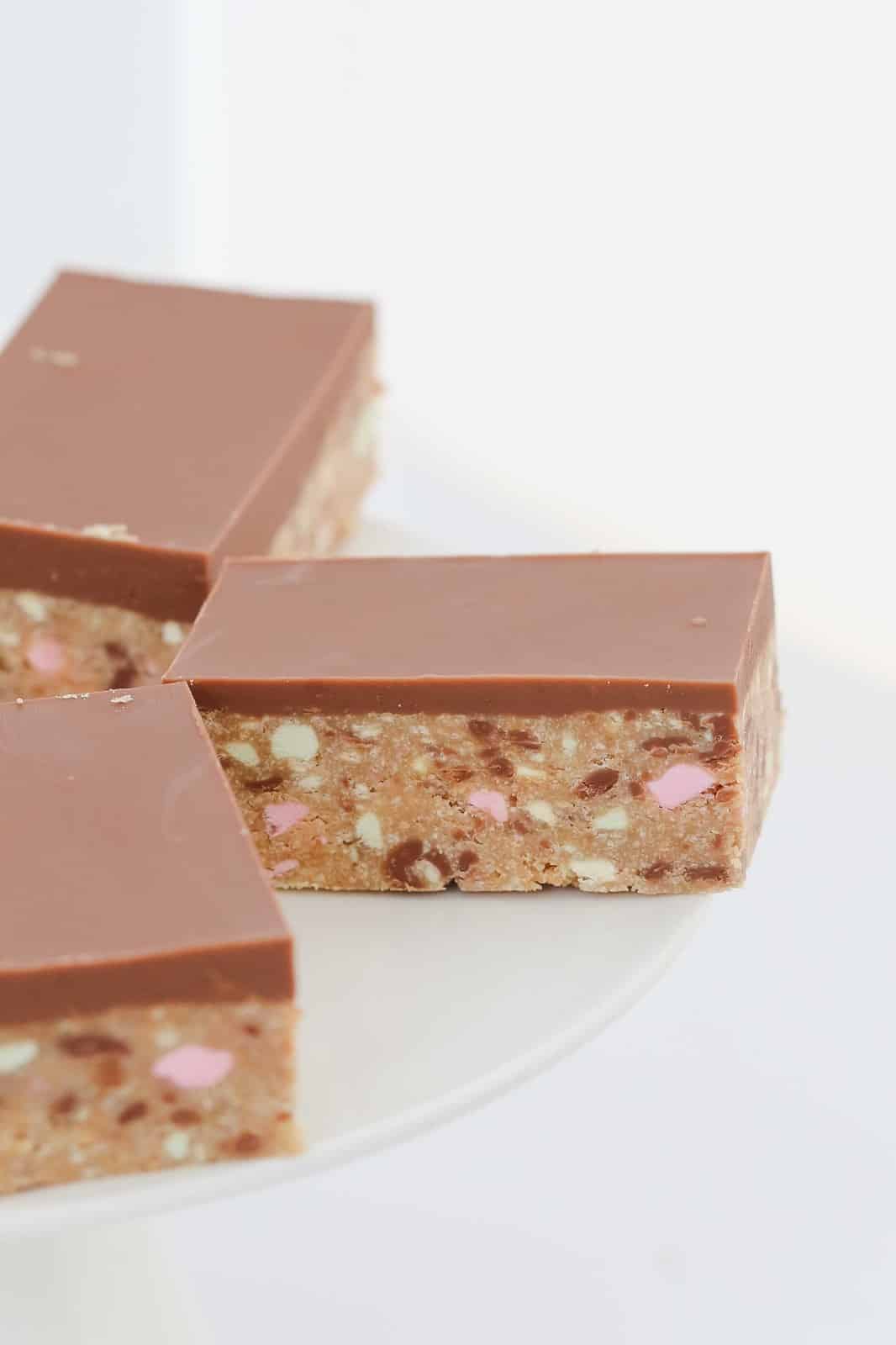 Chocolate topped no-bake slice with pink, green and yellow Clinkers pieces. 