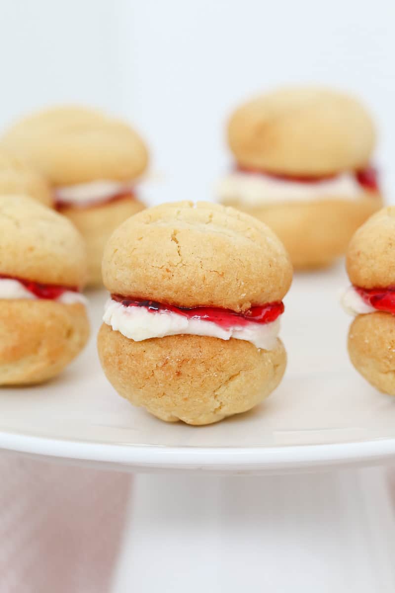A cake plate of biscuits sandwiched with buttercream and jam.
