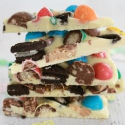 A stack of white chocolate bark wedges made with pieces of Oreo biscuits and colourful M&M's