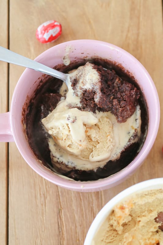 A spoonful of chocolate easter egg mug cake just out of the microwave with ice-cream on top. 