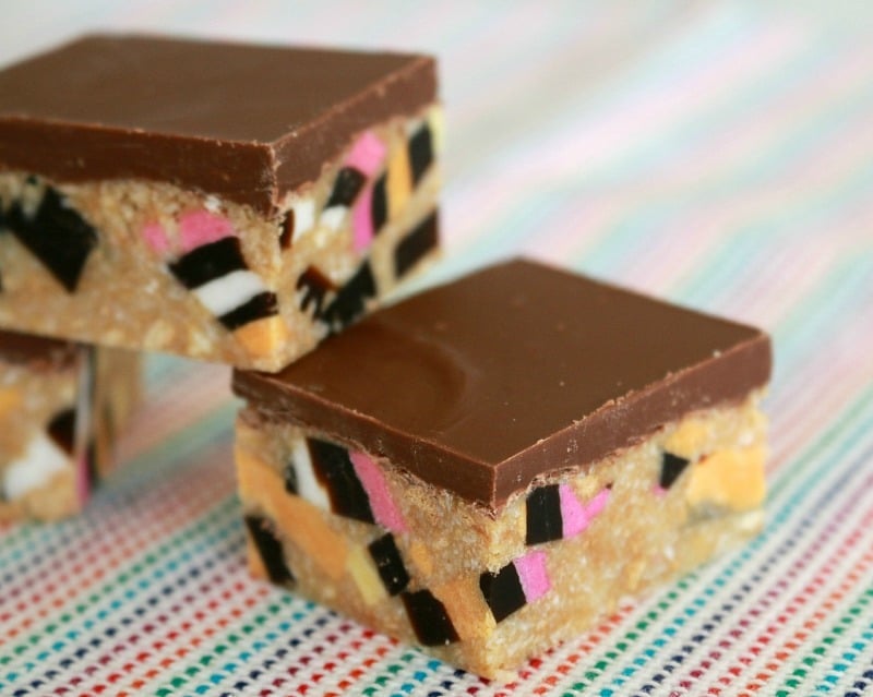 Squares of licorice all-sort slice with a milk chocolate topping and a no-bake filling combined with chopped licorice all-sorts