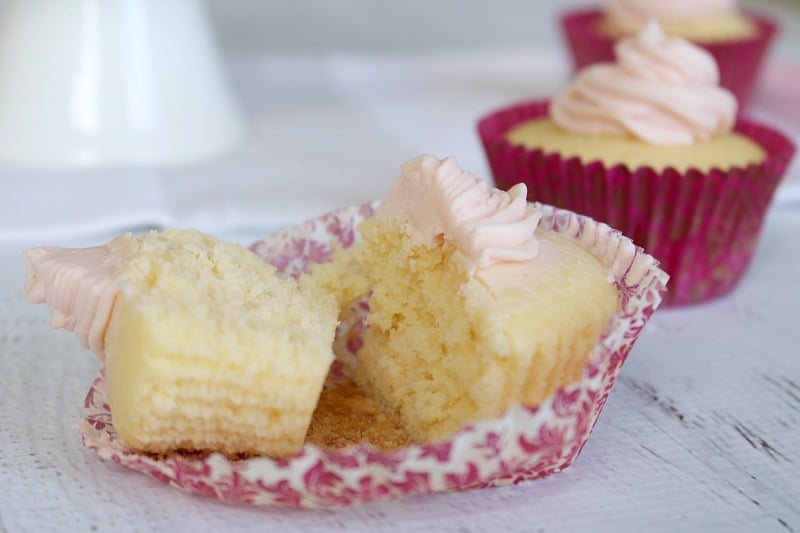 A lemon cupcake in a pink floral cupcake case split in half