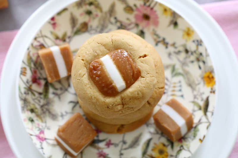 An overhead shot of Jersey Caramel cookies, with more Jersey Caramels around it on a floral plate