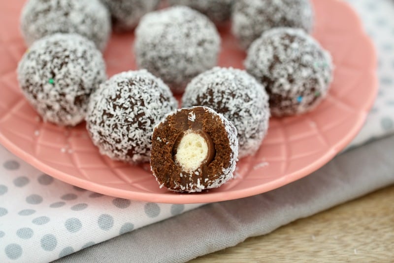 Malteser Balls, with one half eaten, on a pink plate