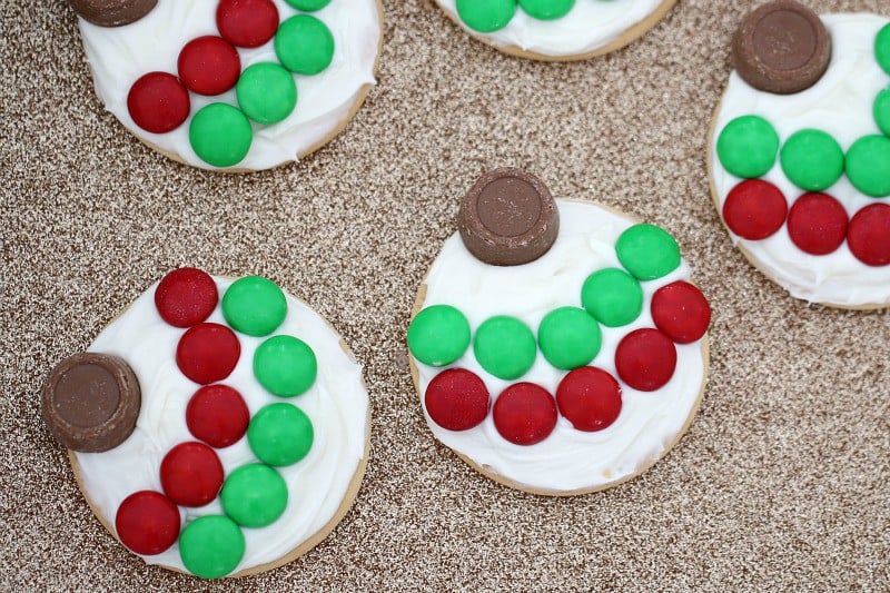 Christmas baubles made from plain biscuits with white frosting, red and green M&M\'s and a chocolate