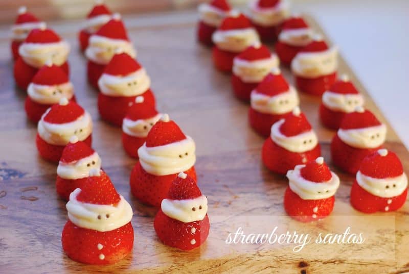 Fresh strawberries cut and decorated with white chocolate to resemble mini Santa Claus bites
