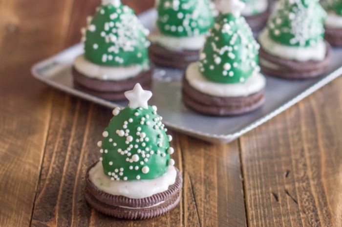 Oreo biscuits with green chocolate coated strawberries and white icing to resemble snowflake covered Christmas trees