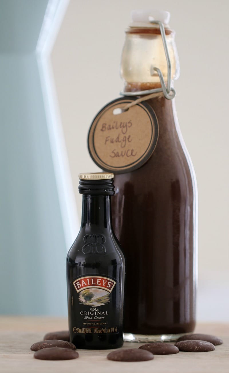 A bottle with a handwritten label 'Baileys Fudge Sauce', next to a small bottle of Baileys Irish Cream