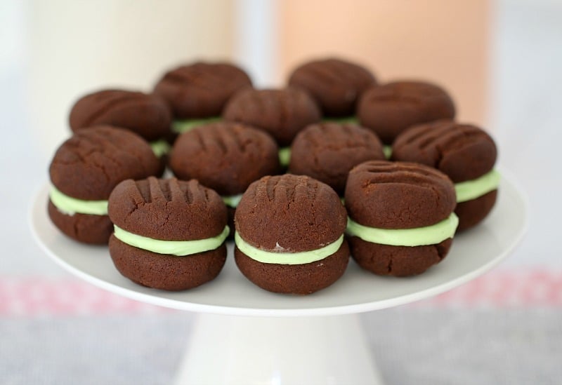A white cake stand filled with choc-mint biscuits