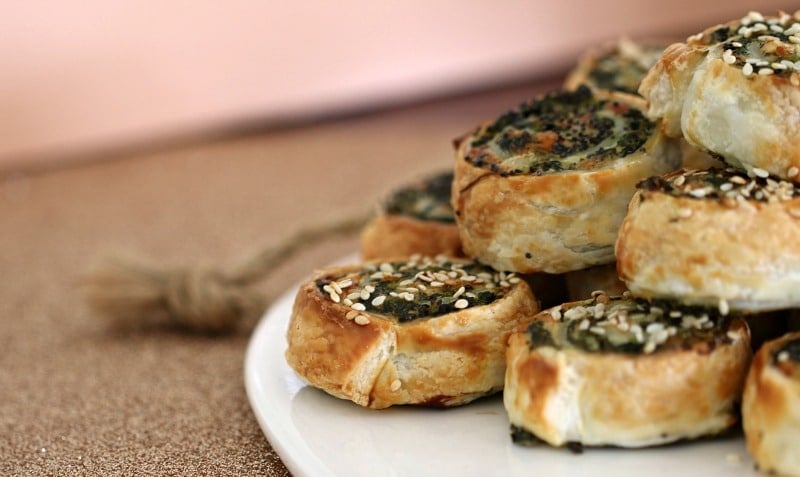 Golden savoury pinwheels, piled on a plate to serve