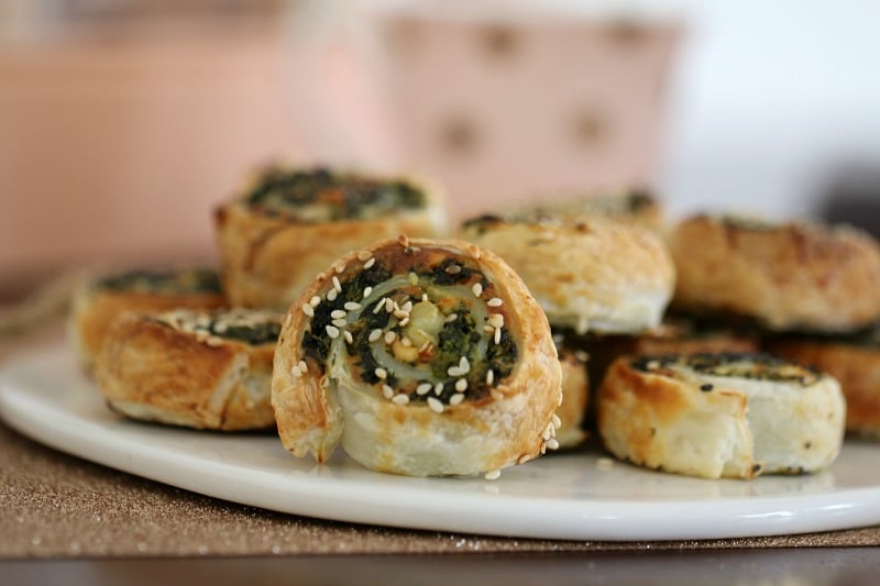 A close up of a pastry pinwheel scroll showing the filling of feta and spinach rolled through it