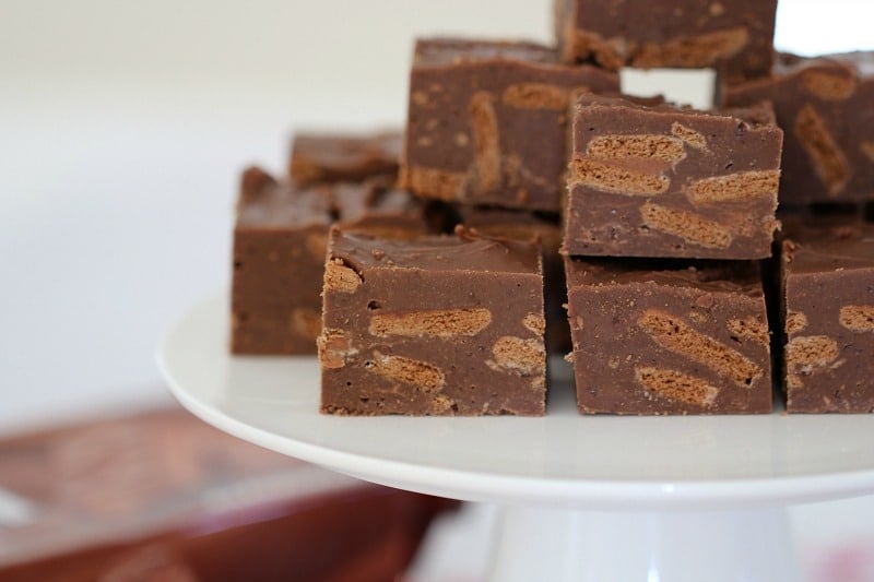 A close up of squares of fudge showing chopped Tim Tam biscuits inside