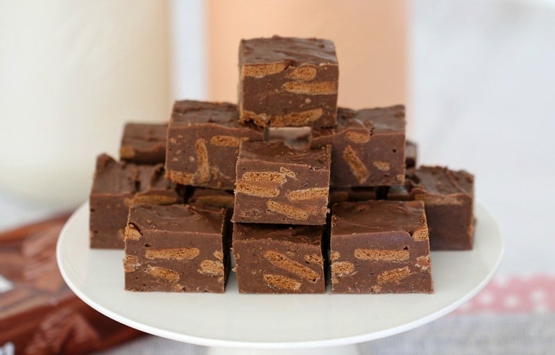 A stack of squares of Tim Tam fudge on a white cake tray