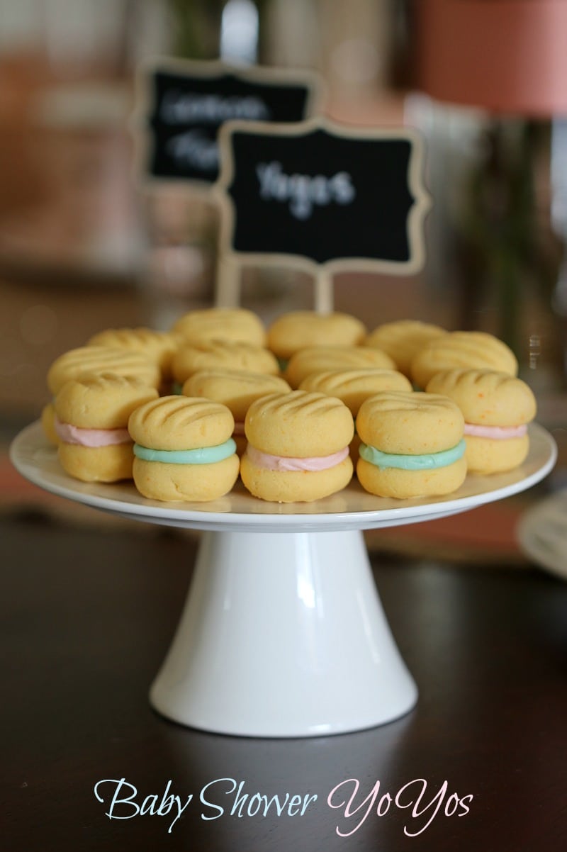 A white cake stand covered with Yo Yo biscuits, sandwiched together with coloured cream icing