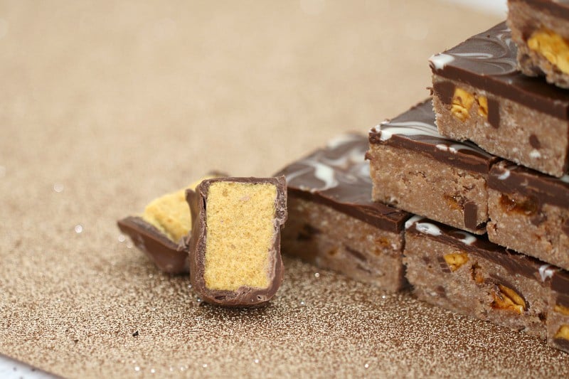 Chopped chocolate honeycomb pieces next to pieces of a chocolate honeycomb slice