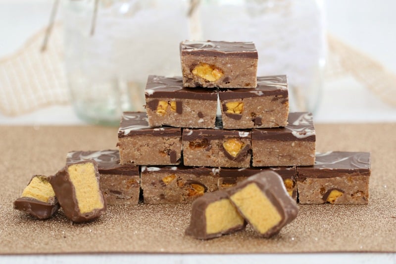 Cut pieces of chocolate honeycomb in front of a stack of slice pieces