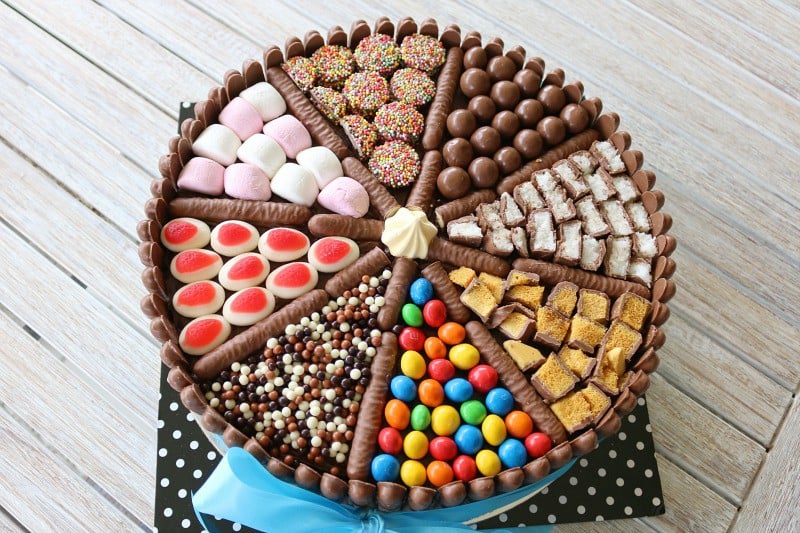 A round cake decorated with brightly coloured chocolates and candies.