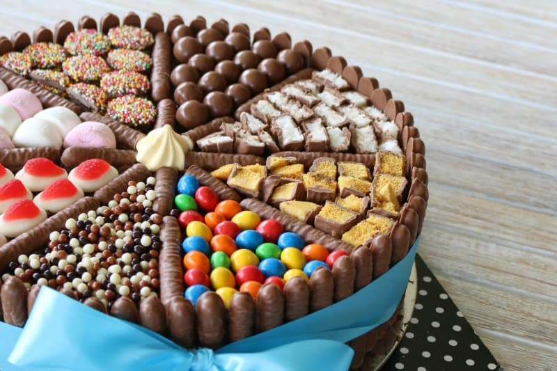 Chocolate honeycomb, M&Ms, bounty bars on a divided chocolate cake.