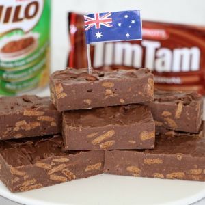 A stack of fudge with an Australian flag in front of a tin of Milo and packet of Tim Tams biscuits