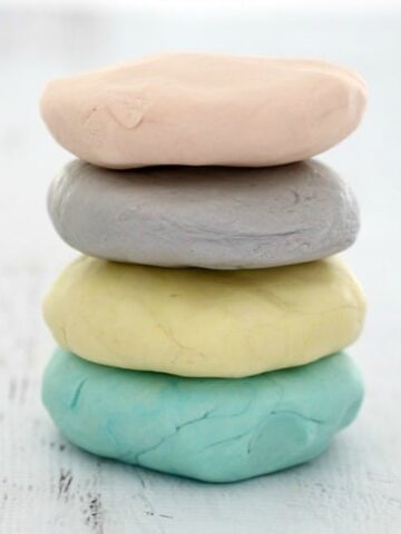 A stack of pink, purple, yellow and blue coloured Playdough