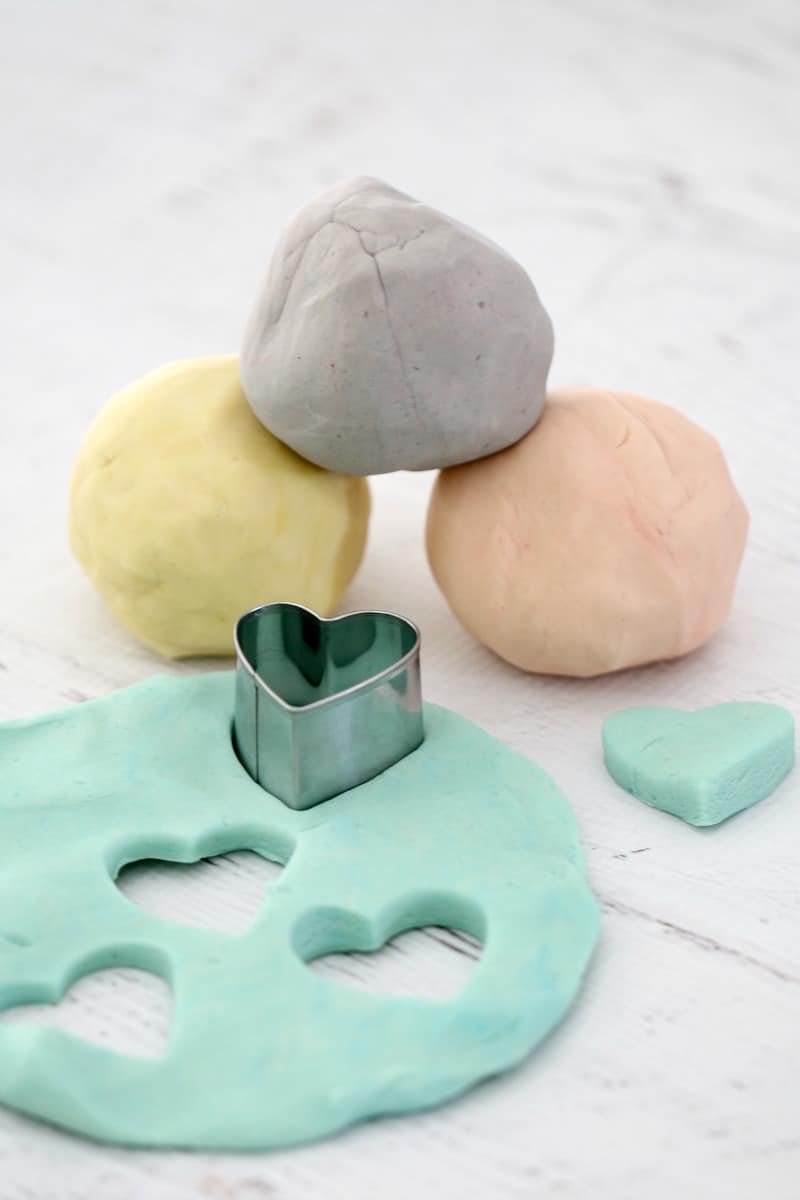 Yellow, purple, pink and green pastel playdough with a metal love heart shaped cutter.