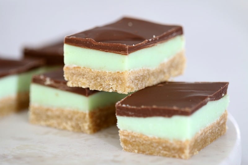 Pieces of peppermint slice with chocolate on top of a pale green minty layer and a baked crumb base