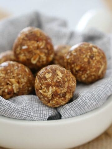A small white bowl filled with a napkin and bliss balls