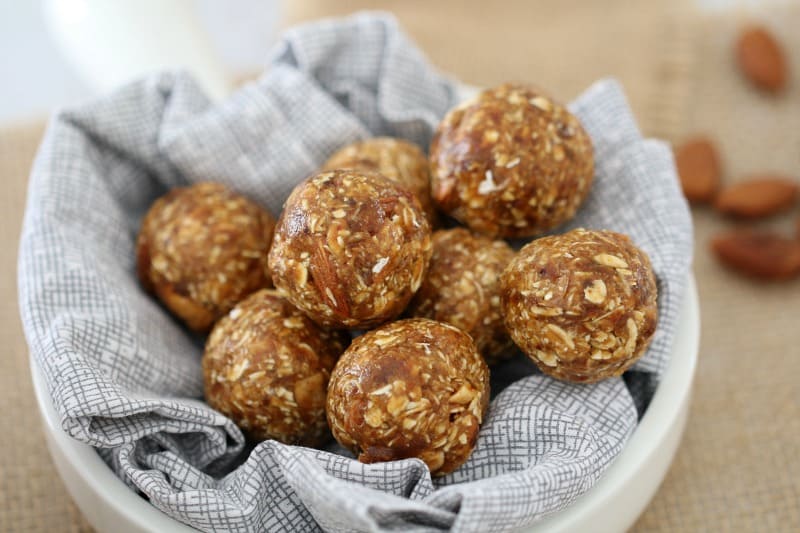A pile of bliss balls sitting on a napkin in a small white bowl