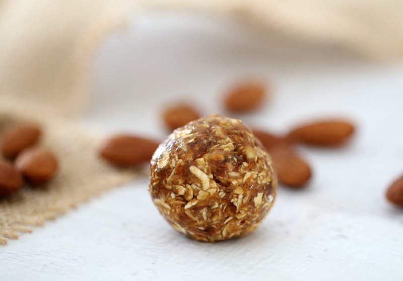 A close up of an energy ball showing the texture of dates, oats and nuts