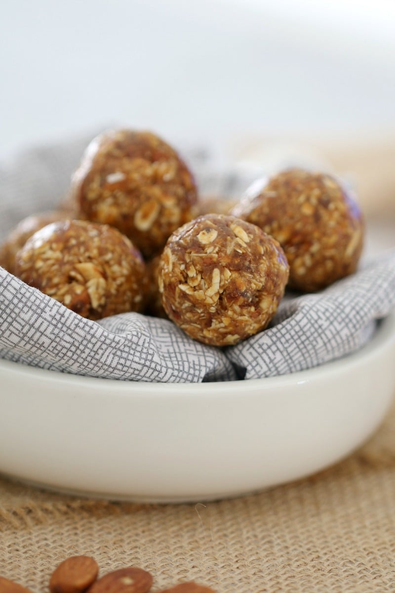 Small round energy balls piled on a napkin in a white bowl