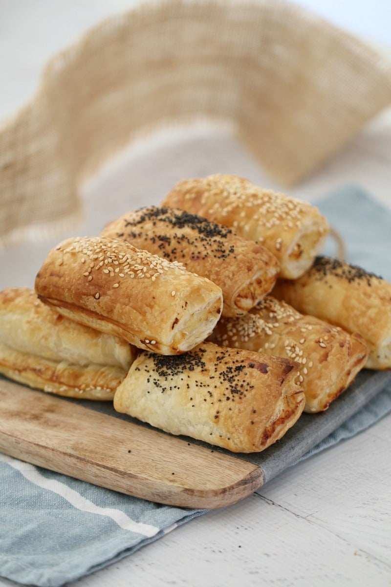 A pile of golden baked sausage rolls made with chicken, cheese and corn