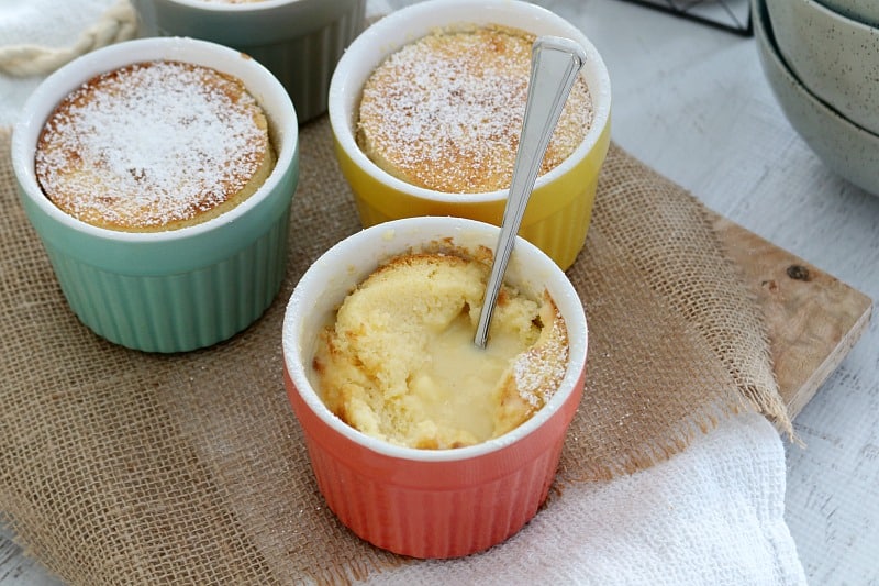 A spoon in a ramekin of creamy baked lemon pudding 
