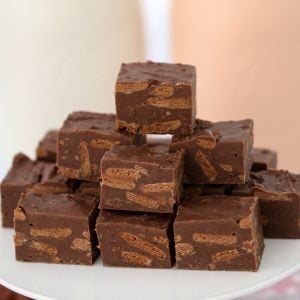 A stack of pieces of fudge showing chopped Tim Tam biscuits inside