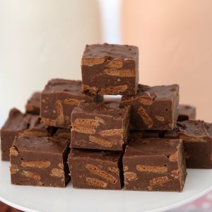 A stack of pieces of fudge showing chopped Tim Tam biscuits inside