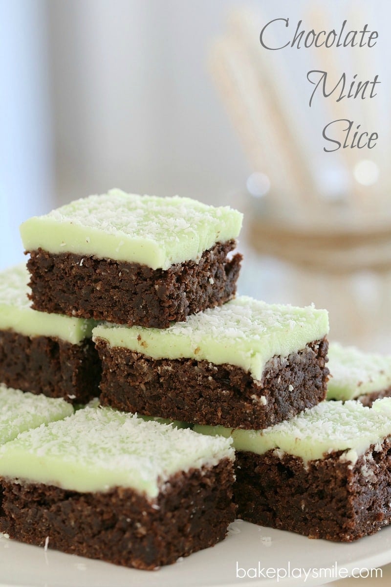 A stack of chocolate slice pieces with mint icing and sprinkled with coconut