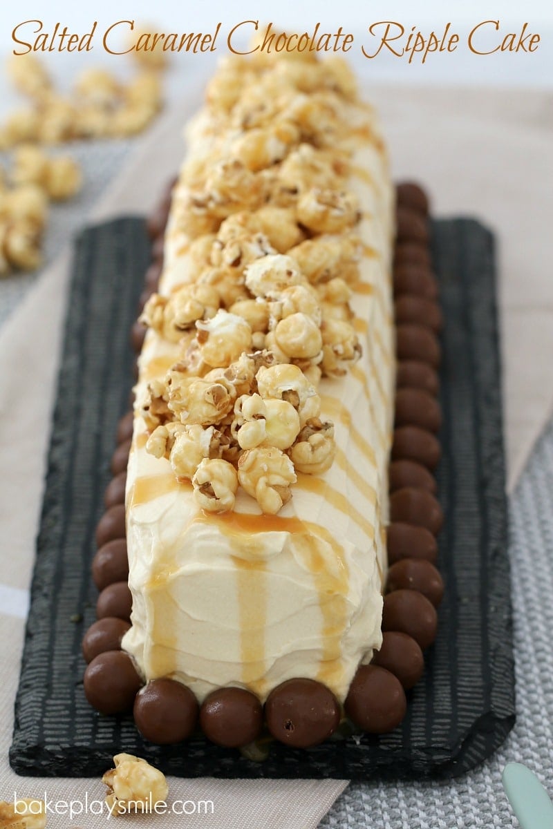 An overhead shot of a log cake covered in cream, with Malteser balls around the base and popcorn drizzled with caramel sauce on top