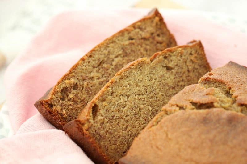 Thick banana bread slices cut next to the rest of the loaf