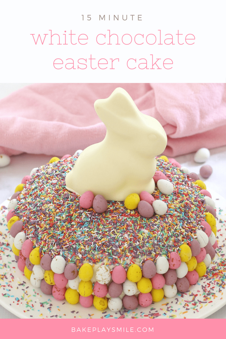 An easter cake with sprinkles, colourful easter eggs and a white chocolate bunny. 