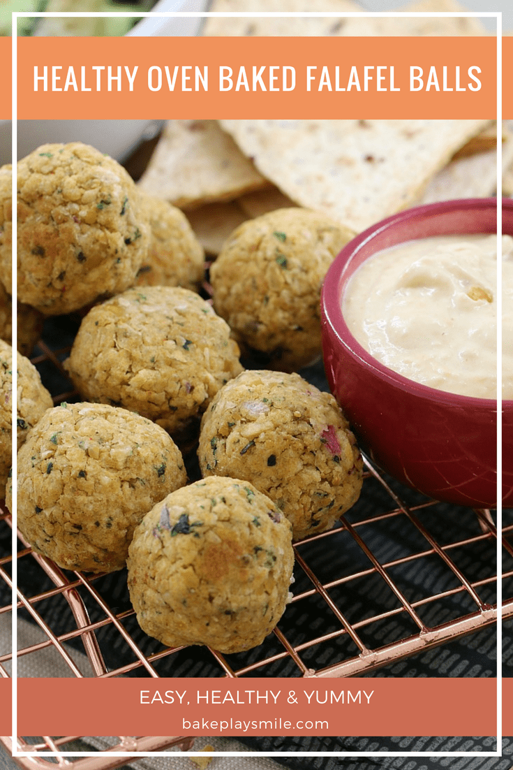 A close up of falafel balls and pita bread next to a bowl of hommus