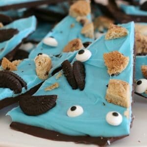Wedges of Cookie Monster Chocolate Bark made with a blue candy topping and decorated with broken Oreo biscuits, choc chip cookies and edible eyes