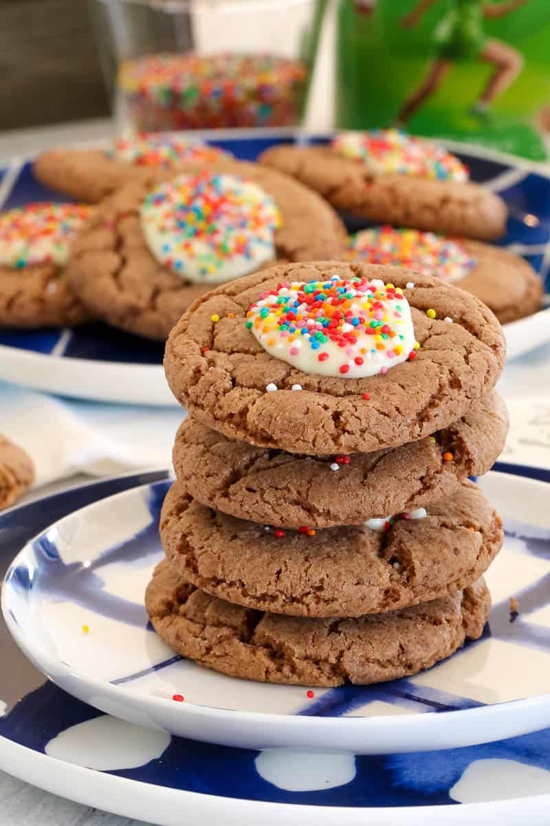 A stack of chocolate malted milk cookies with white chocolate and sprinkles. 