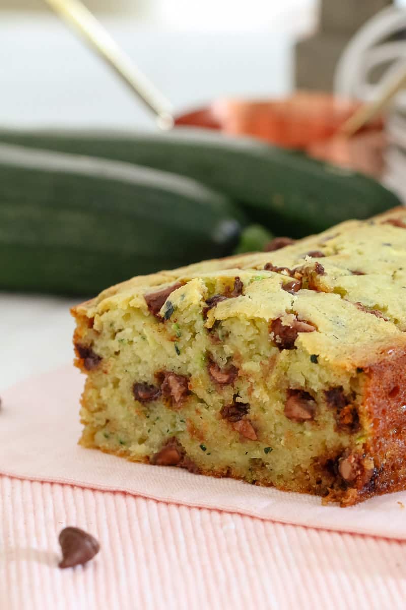 A baked loaf with the end cut to show texture made with grated zucchini and chocolate chips