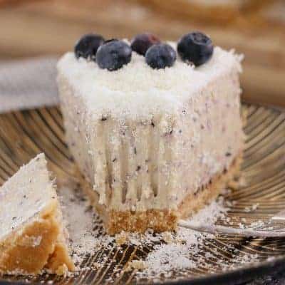 A delicious no-bake White Chocolate & Blueberry Cheesecake decorated with fresh blueberries and grated chocolate. This is the perfect summer dessert!