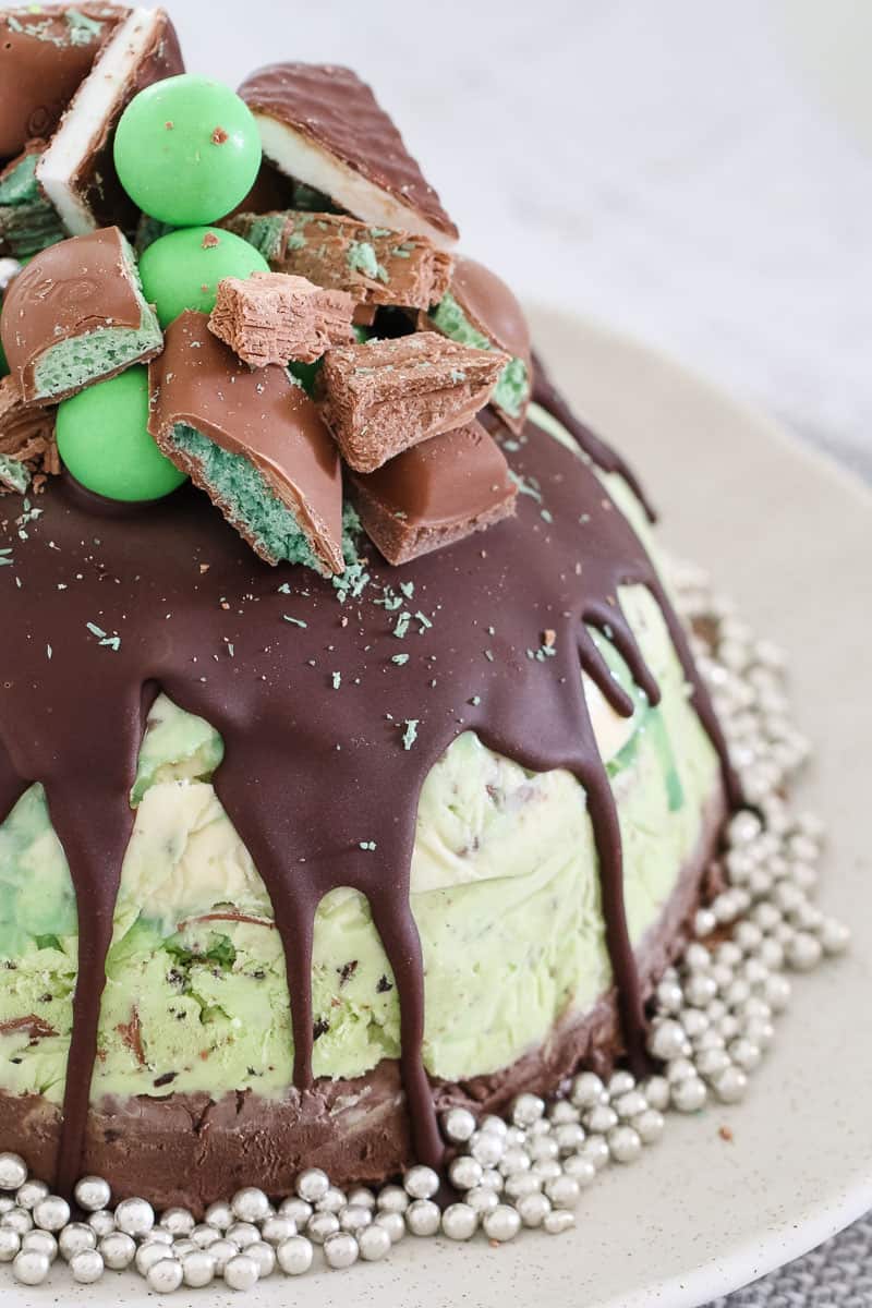 A mint chocolate ice cream cake with chopped up chocolate bars and mint flavoured chocolates. 