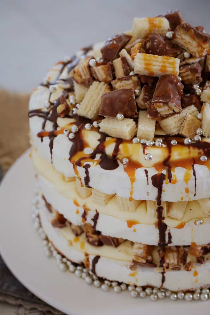 A three layered pavlova, drizzled with chocolate and caramel, and topped with chopped Picnic Bars and wafer biscuits