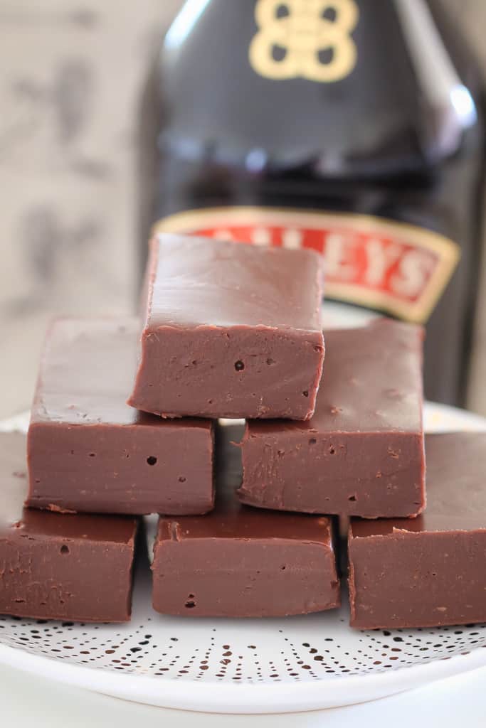 A stack of chocolate fudge in front of a bottle of Baileys