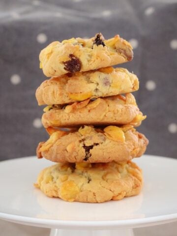 A stack of chocolate chip and sultana cookies on a round cake tray