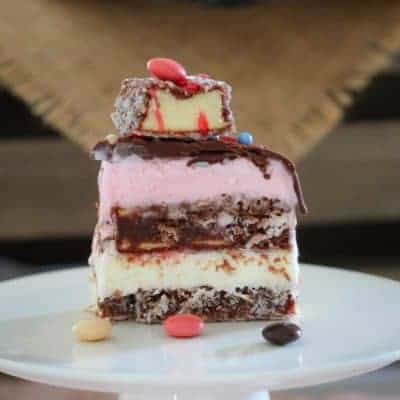 A deliciously layered Lamington Ice-Cream Cake inspired by everyone's favourite treat! Strawberry ice-cream, chocolate lamington fingers, vanilla ice-cream and raspberry topping make this no-bake dessert a total winner!