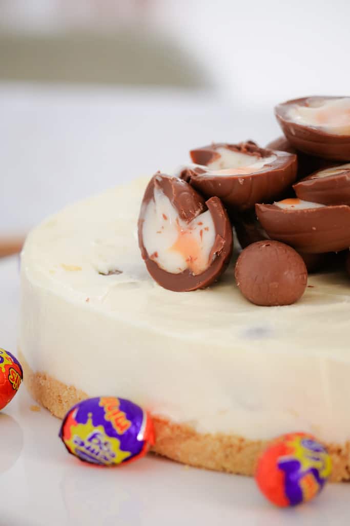 Cadbury Creme Eggs cut in half and oozing over a white chocolate cheesecake. 