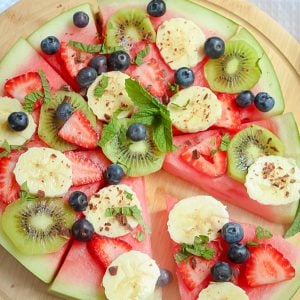 This healthy Watermelon Pizza topped with fresh berries, sliced banana, kiwi fruit, creamy passionfruit yoghurt and grated chocolate is the perfect kid-friendly treat.